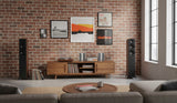 Modern living room with a brick wall, wooden cabinet, and speakers.